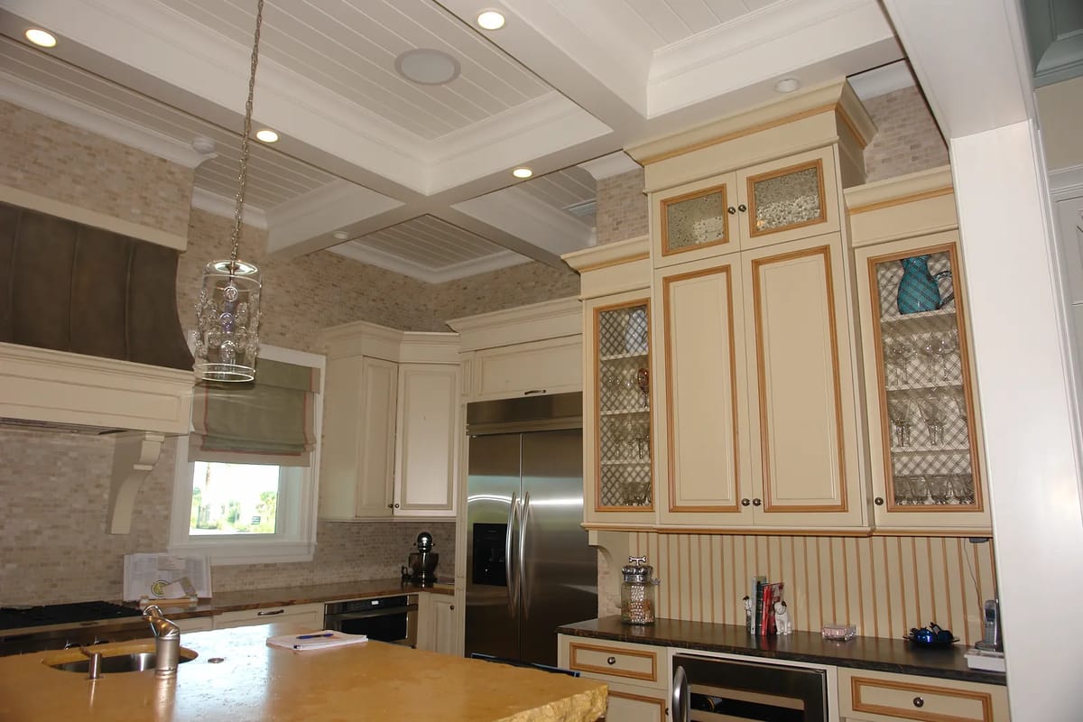 Kitchen with beige cabinets, stainless steel refrigerator, built-in oven, granite countertops, and central island.