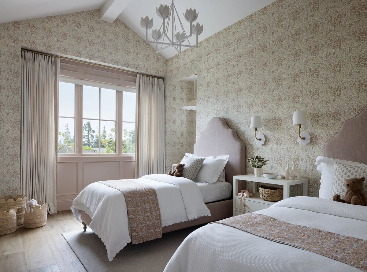 Bedroom with twin beds, floral wallpaper, large window, nightstands, and decorative ceiling light.