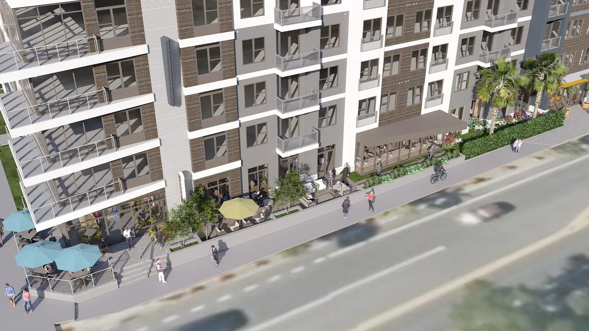 Exterior view of a multi-story building with balconies, seating areas, and landscaping.