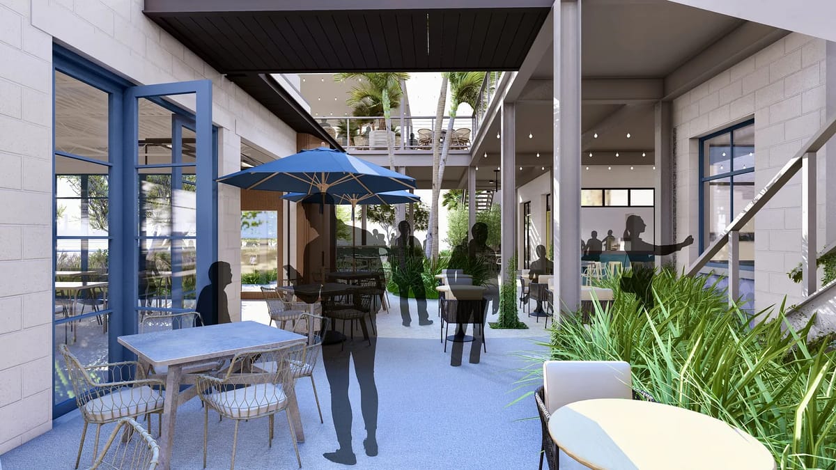 Patio with seating areas, round tables, chairs, an umbrella, and surrounding greenery.