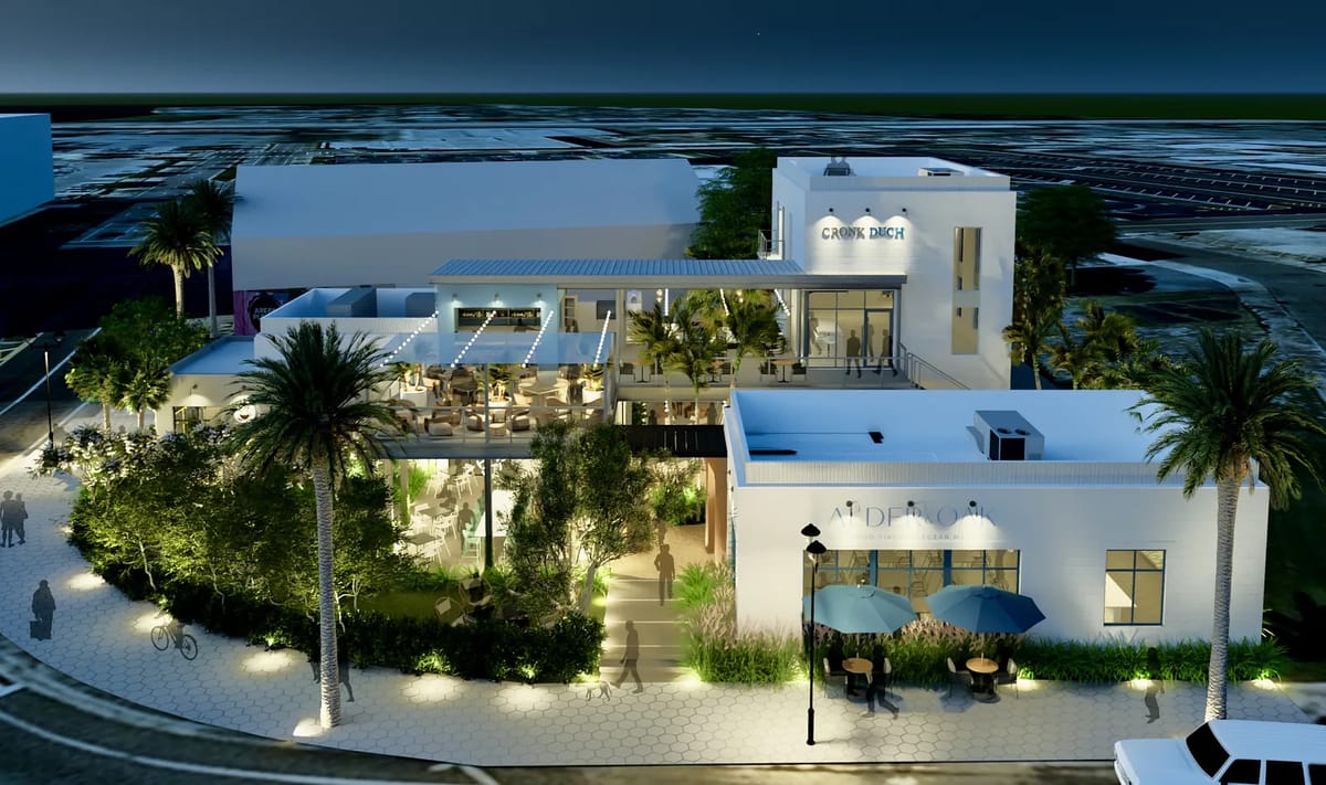 Exterior front of a restaurant with large windows, outdoor seating, and surrounding greenery.