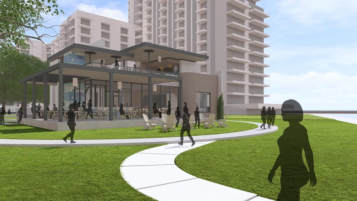 Exterior view of a modern building with glass windows, patio, and landscaped areas with people walking.