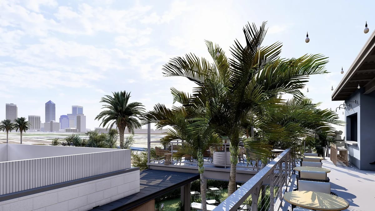 Outdoor deck with palm trees, lounge chairs, and a city skyline view.