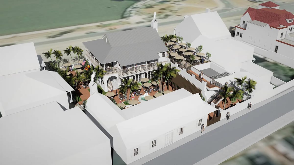 Outdoor space with palm trees, tables, staircase, and surrounding buildings with gabled roofs.