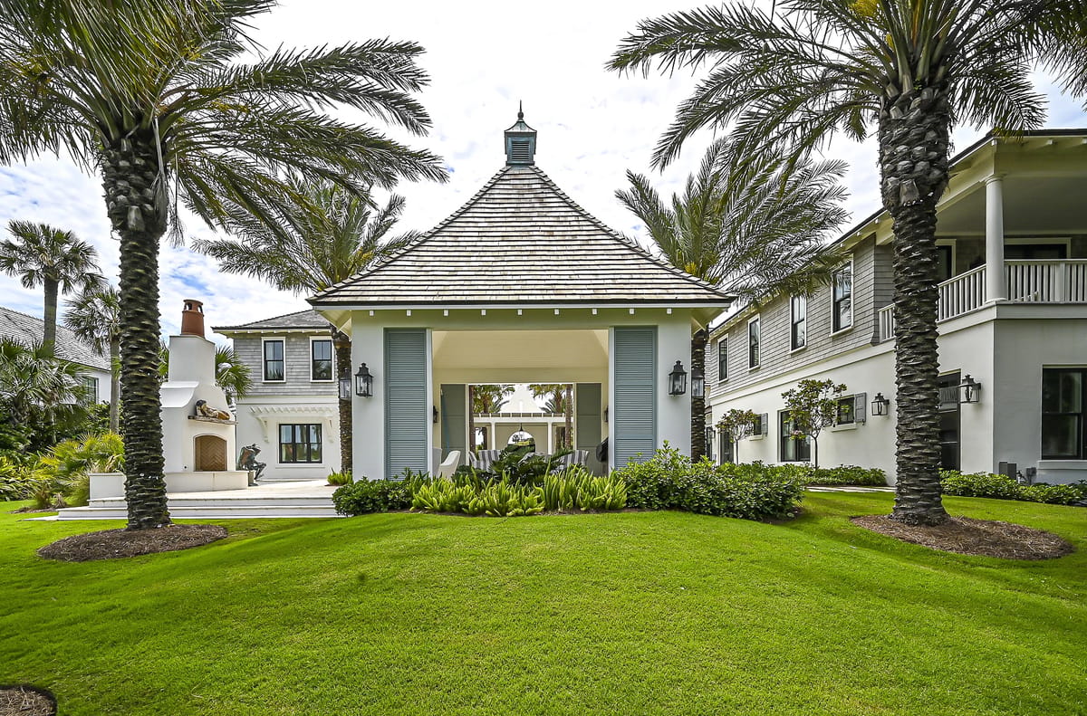 Exterior front view featuring a gazebo with palm trees and landscaped grass.