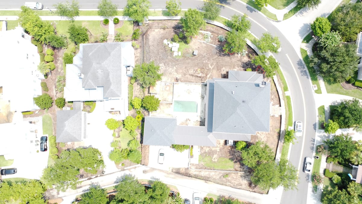 Aerial view of a residential area with multiple houses and a partially cleared lot.