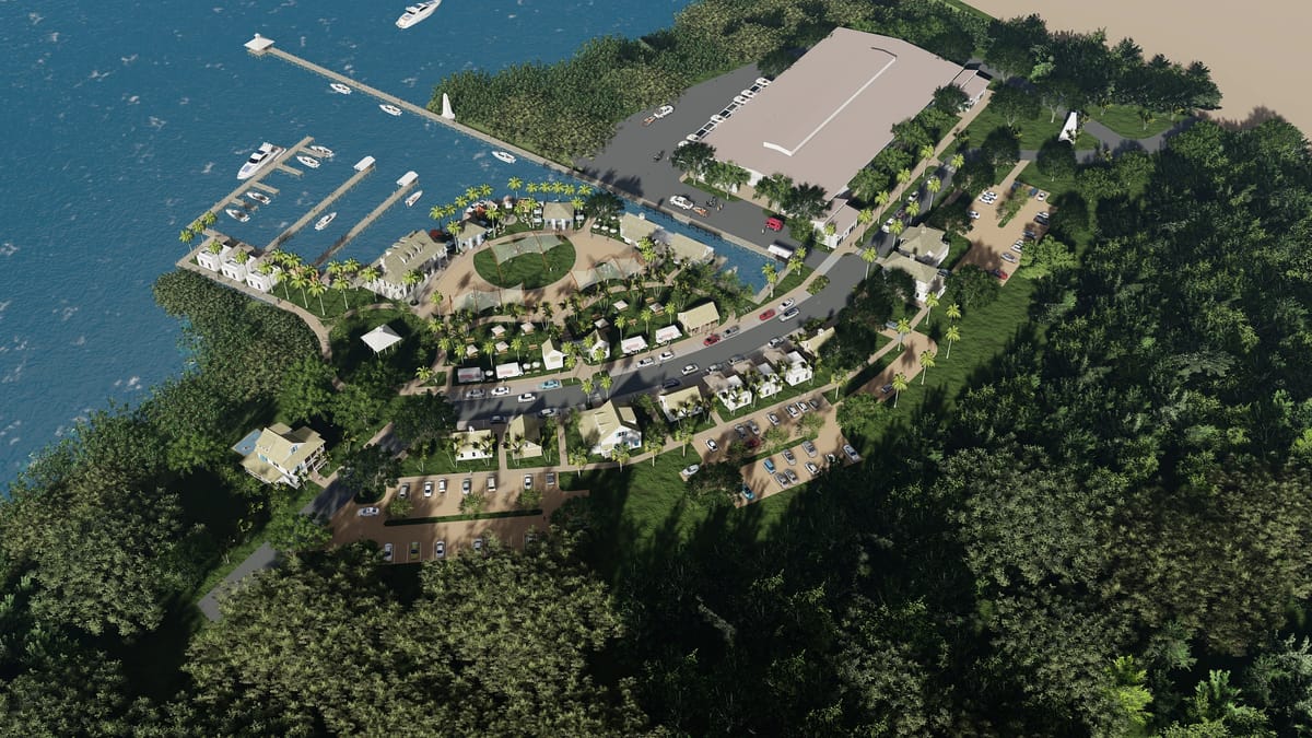 Aerial view of coastal development with residential buildings, marina, parking, and landscaped gardens.