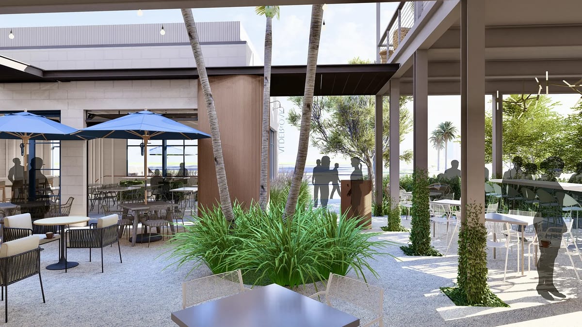 Outdoor patio with tables, chairs, umbrellas, and various plants in a gravel setting.
