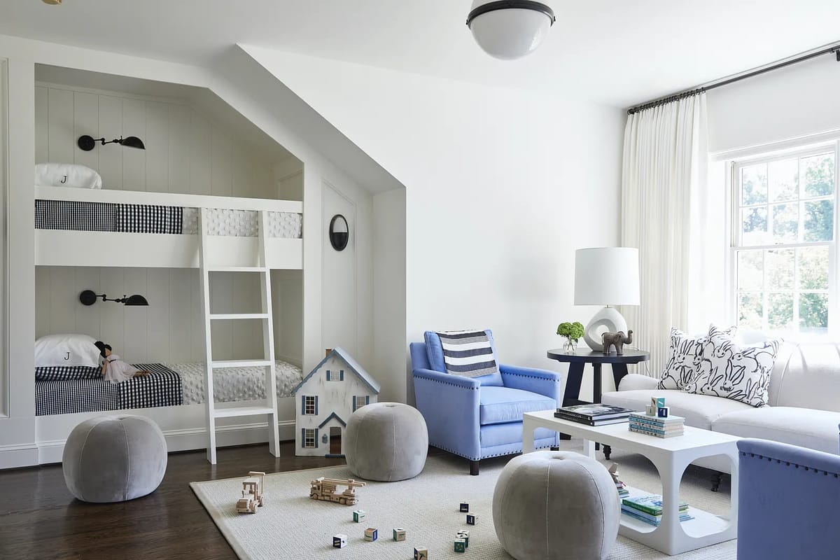 Multifunctional room with bunk beds, blue armchair, white sofa, and light area rug.