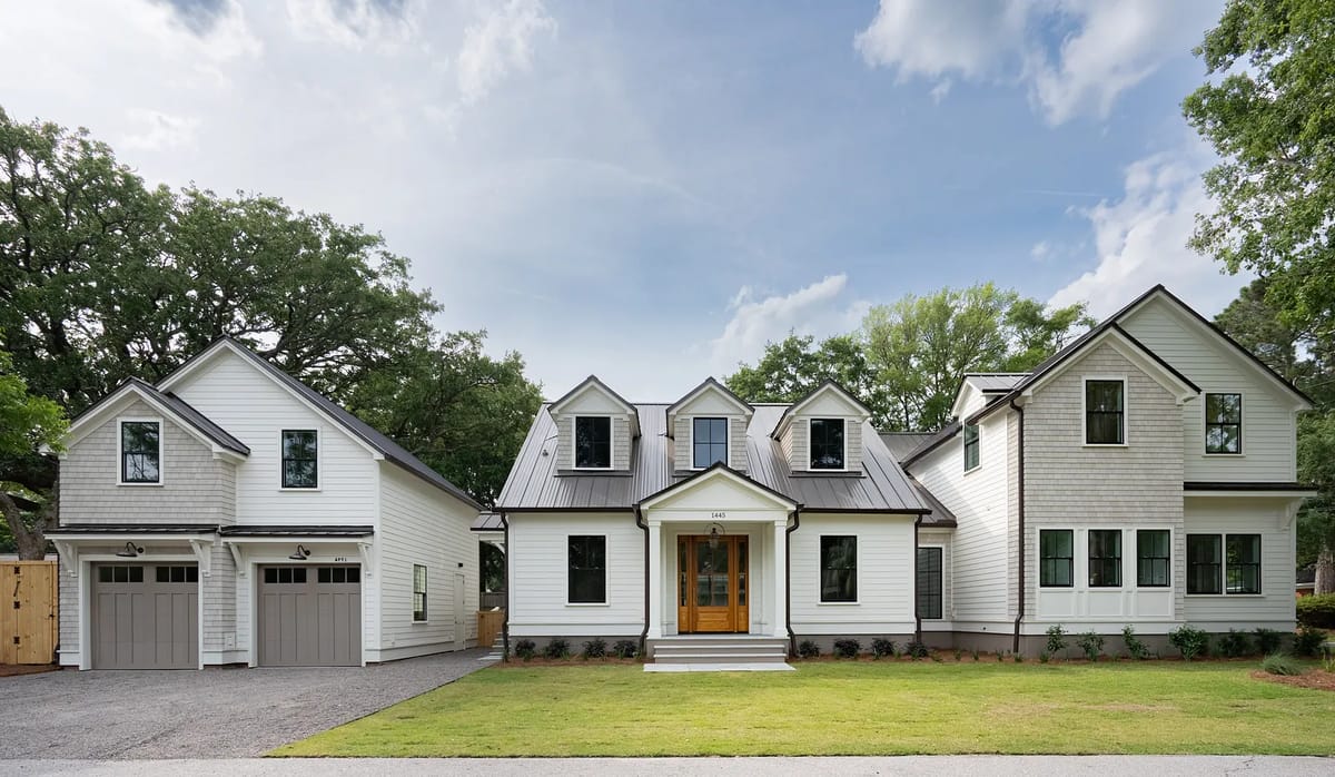 Exterior front of a house with double door entry, garage, gabled roof, and landscaped area.