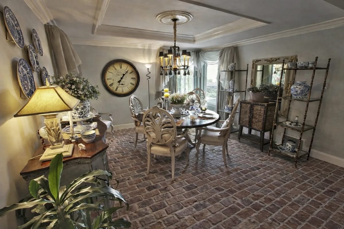 Dining room with round table, chairs, decorative plates, vintage clock, and sideboard.