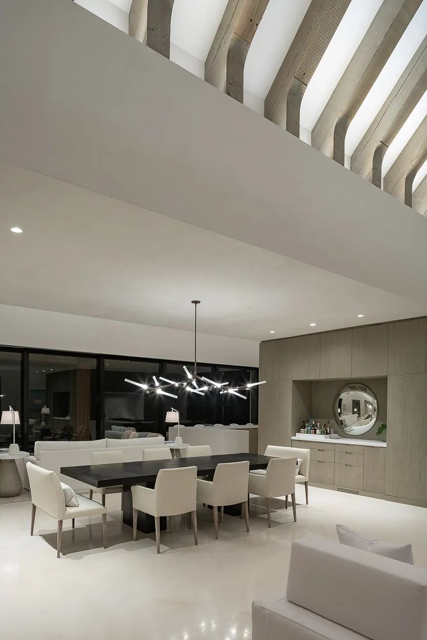 Dining room with rectangular table, eight chairs, large windows, built-in cabinet, and pendant lighting