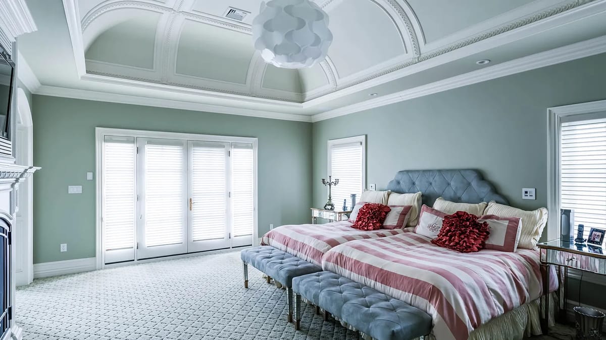 Bedroom with king-sized bed, upholstered benches, textured rug, French doors, and coffered ceiling