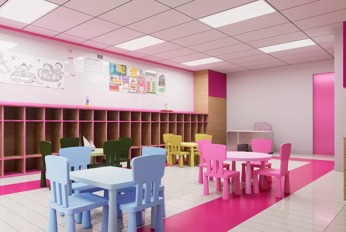 Classroom space with colorful tables, chairs, shelving unit, and educational posters on pink accented walls.