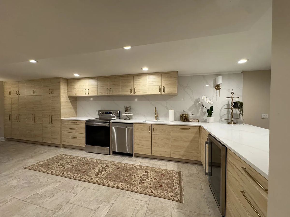 Kitchen with wood cabinets, white countertops, stainless steel appliances, and a patterned area rug