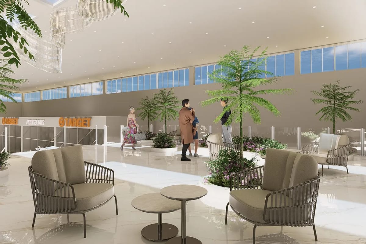 Commercial space with seating areas, large windows, indoor plants, and polished white flooring.