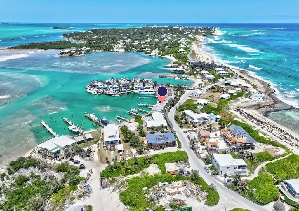 Aerial view of coastal area with homes, water, docks, and roads.