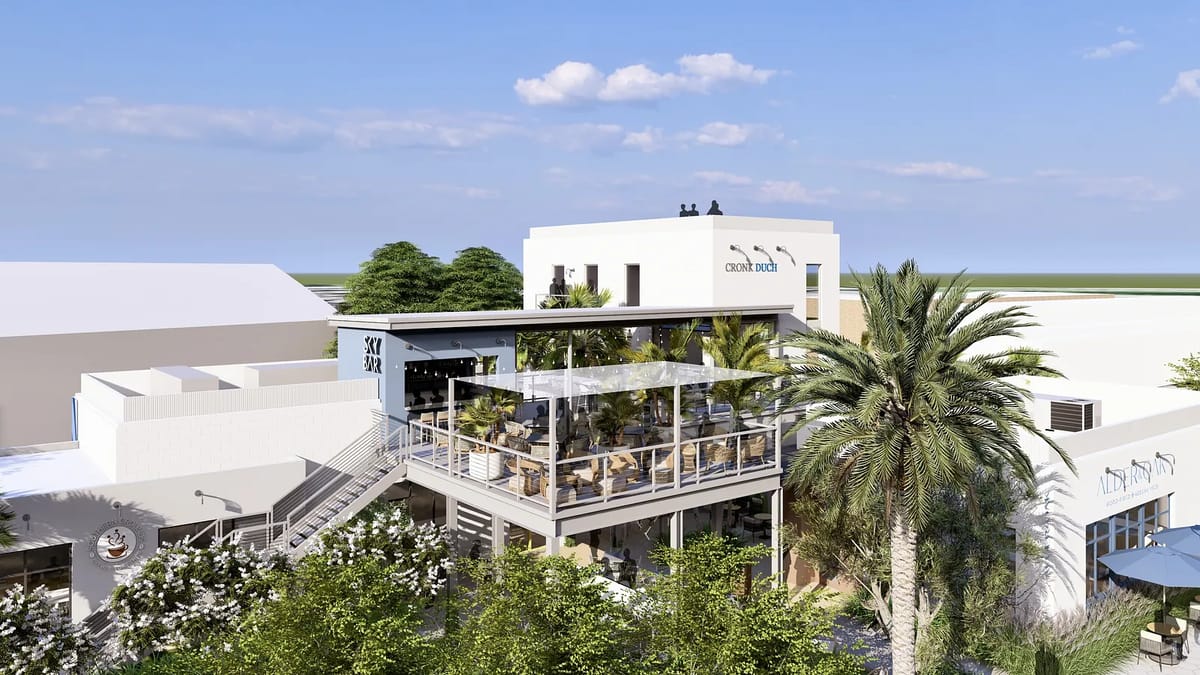 Exterior view of building with patio, outdoor seating, greenery, staircase, and large windows.