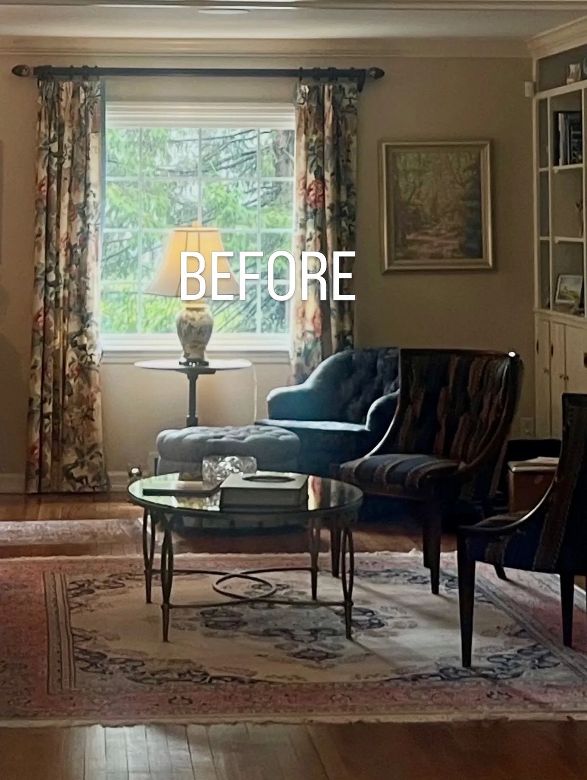 Living room with blue armchair, brown striped armchair, glass coffee table, floral curtains, and an oil painting.
