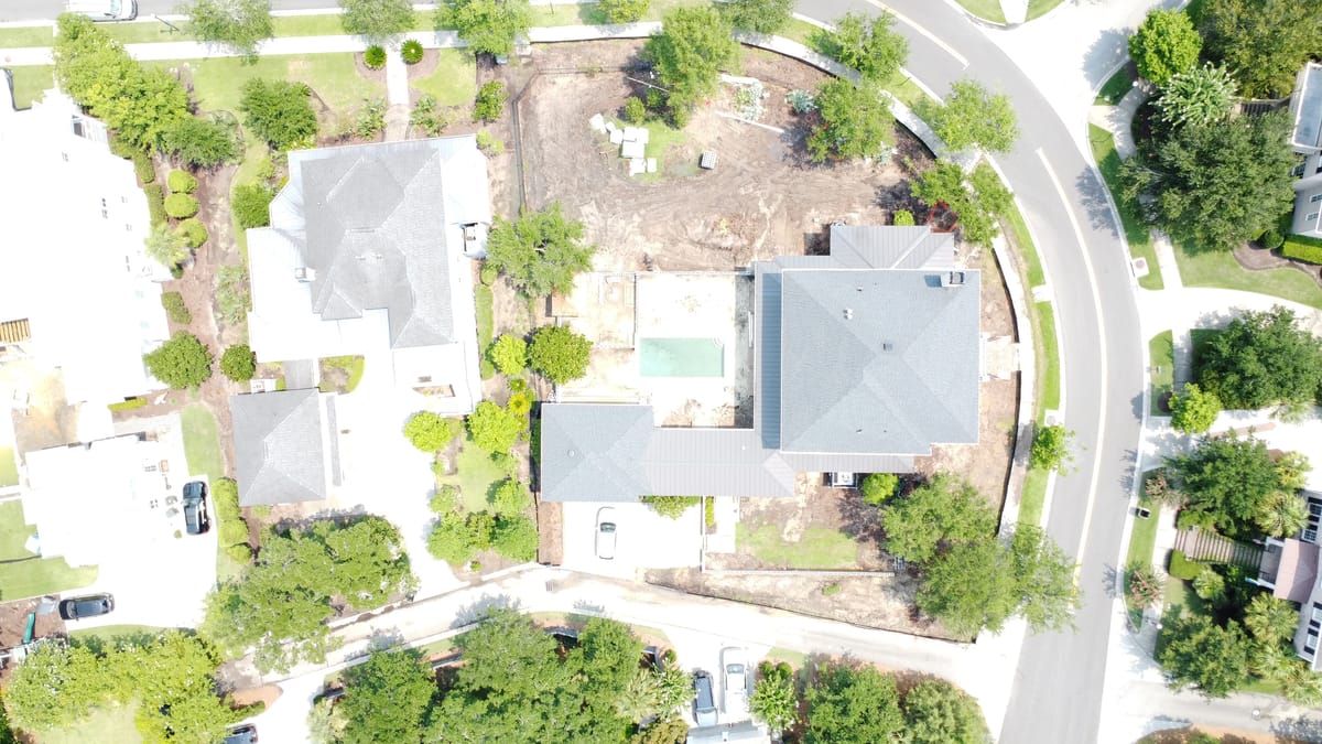 Aerial view of a neighborhood with residential houses, landscaping, and a circular street.