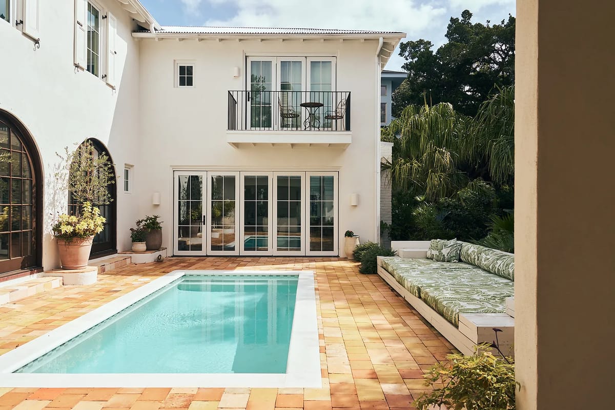 Exterior rear space with swimming pool, outdoor sofa, balcony, potted plants, and terracotta tile flooring