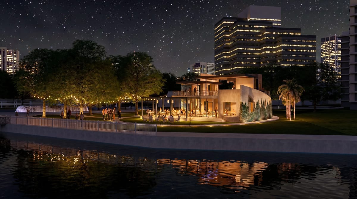 Outdoor gathering area with modern building, trees, seating, and lights by a body of water.