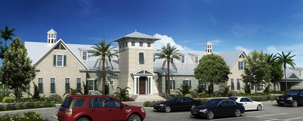 Exterior facade of a stone building with gabled roofs, large windows, and a parking lot.