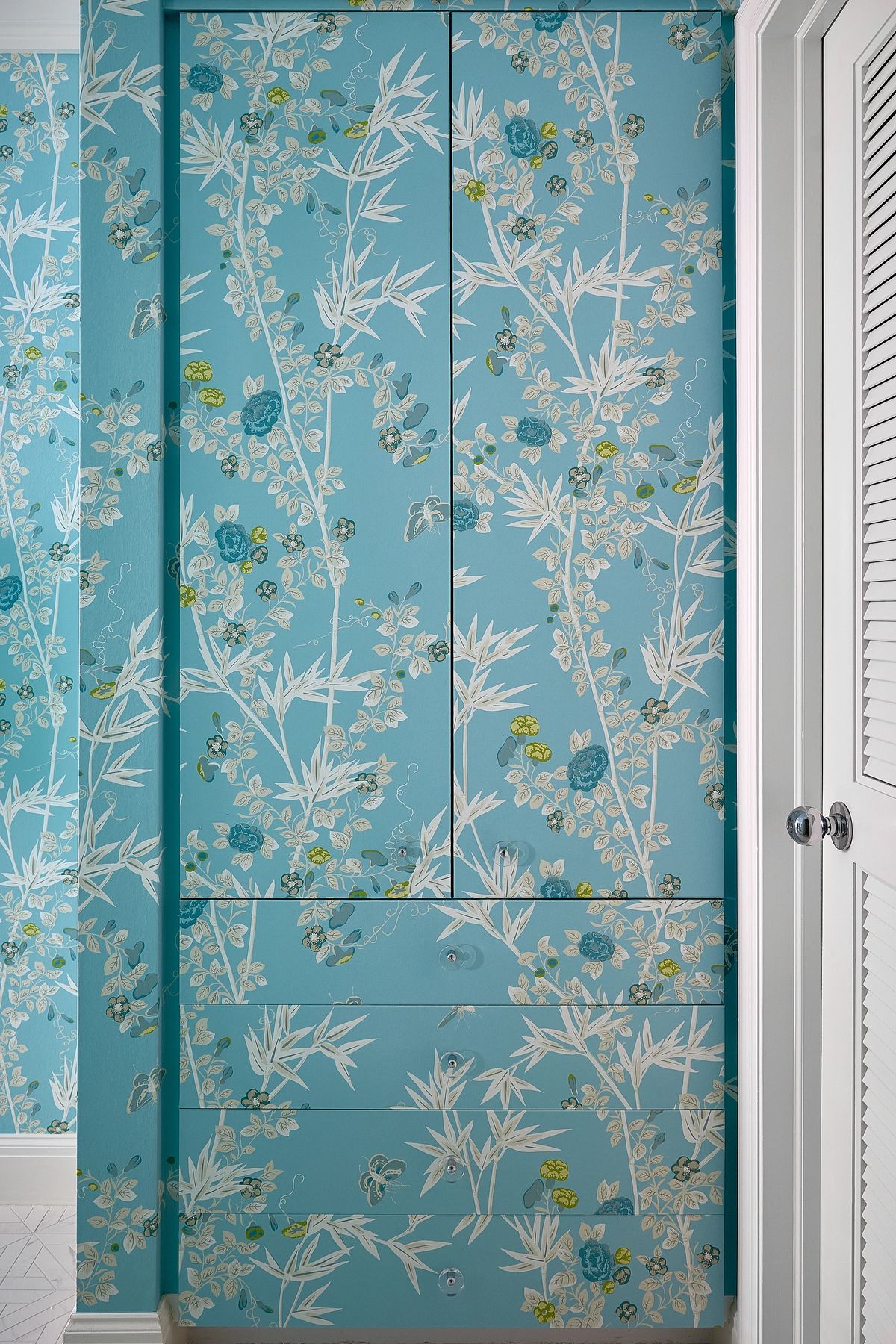 Storage cabinet with floral-patterned doors and drawers against white walls.