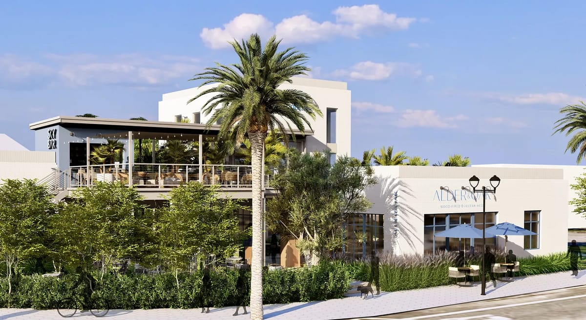 Exterior view of a building with glass windows, deck, palm trees, and a branded sign.
