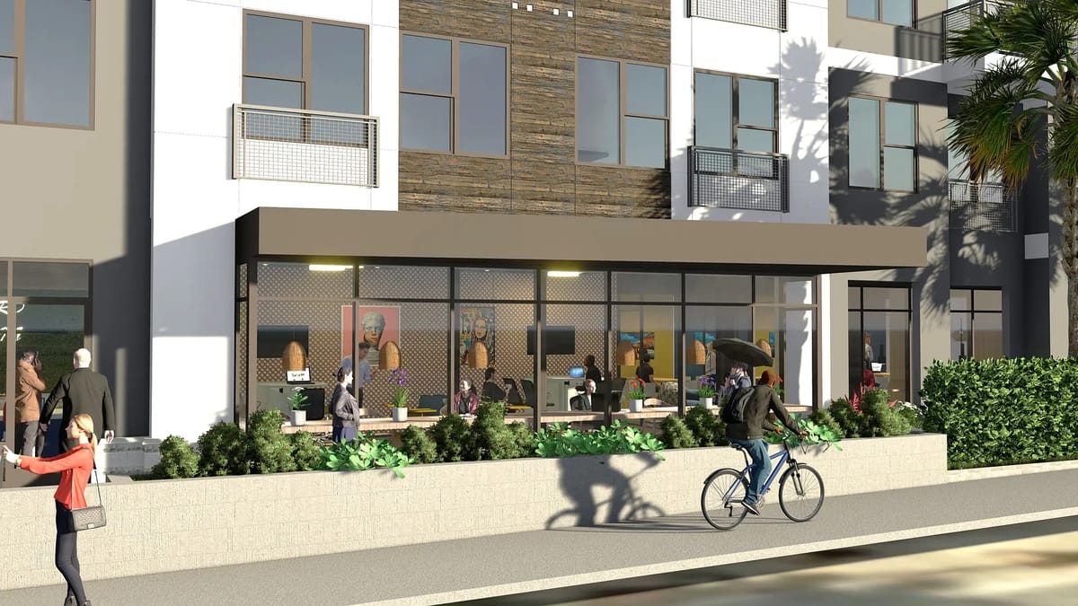Exterior front view of a building with large windows, wooden accent wall, and seating areas with people outside.