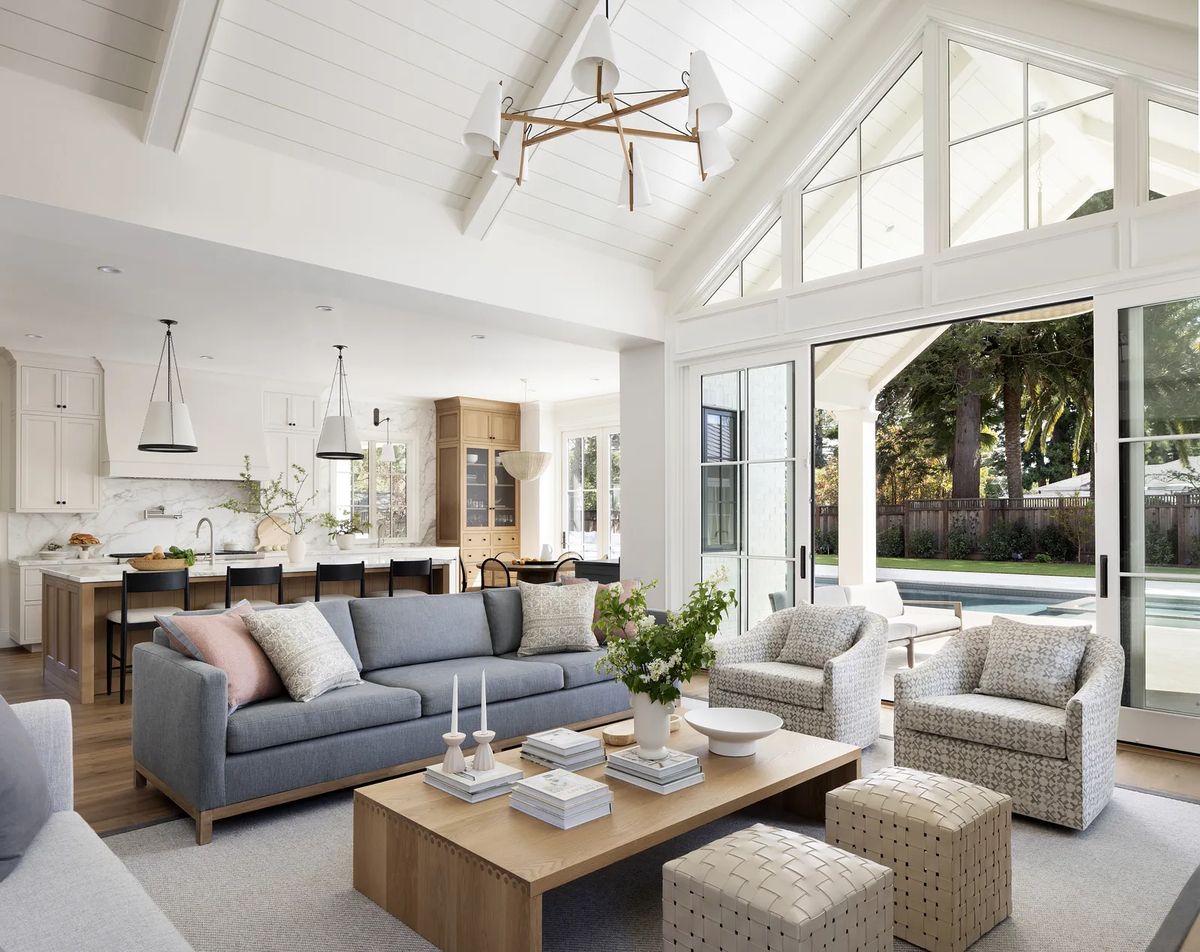 Living room with gray sofa, accent chairs, wooden coffee table, and large sliding door to outdoor space.