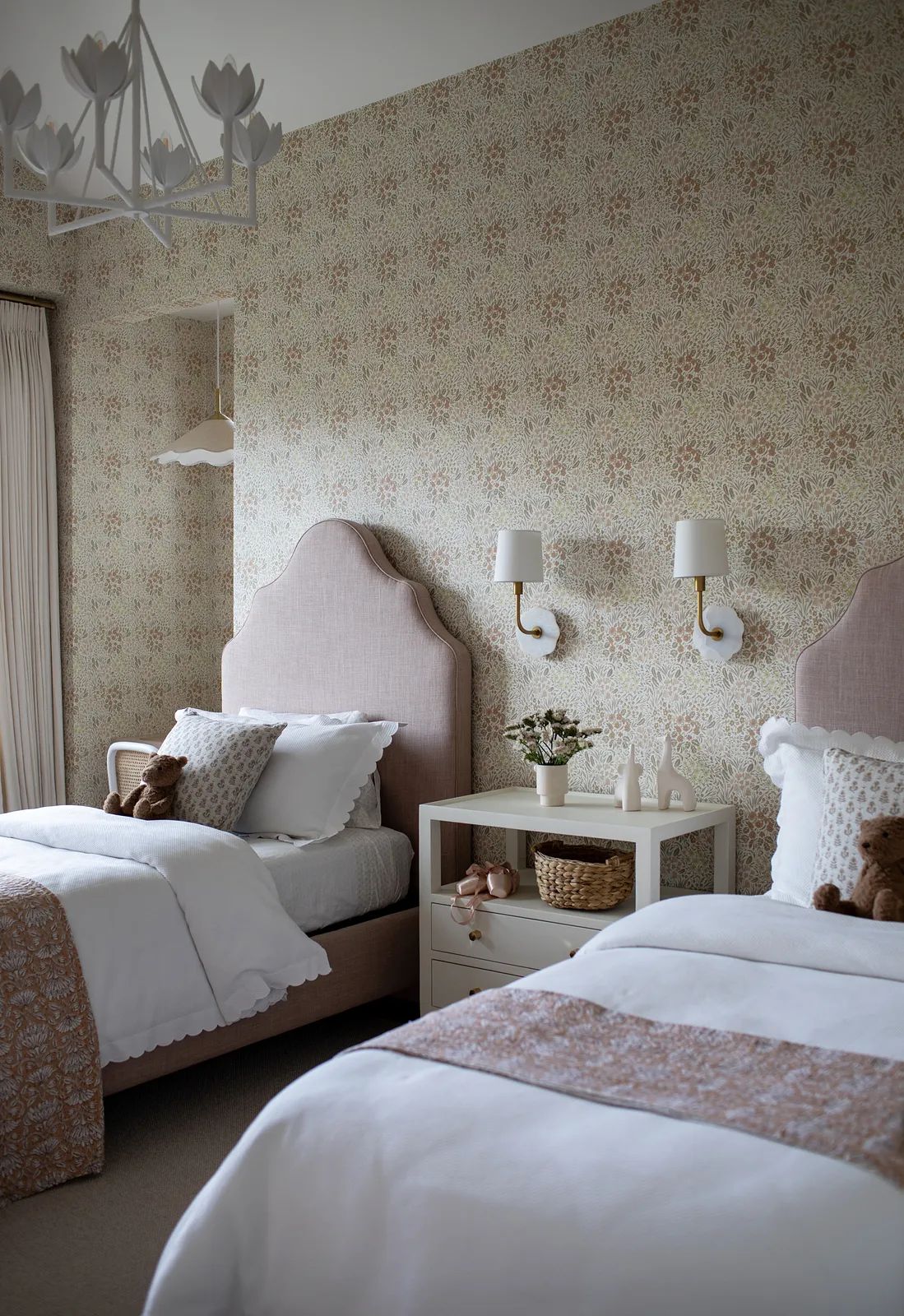 Bedroom with two twin beds, tufted headboards, floral wallpaper, nightstand, and wall sconces