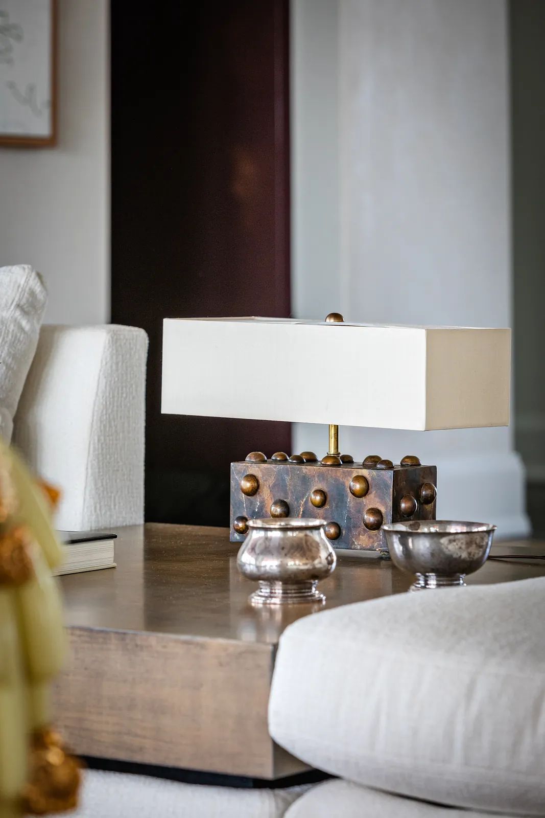 Indoor setting with coffee table, decorative lamp, small accessories, and a light-colored sofa