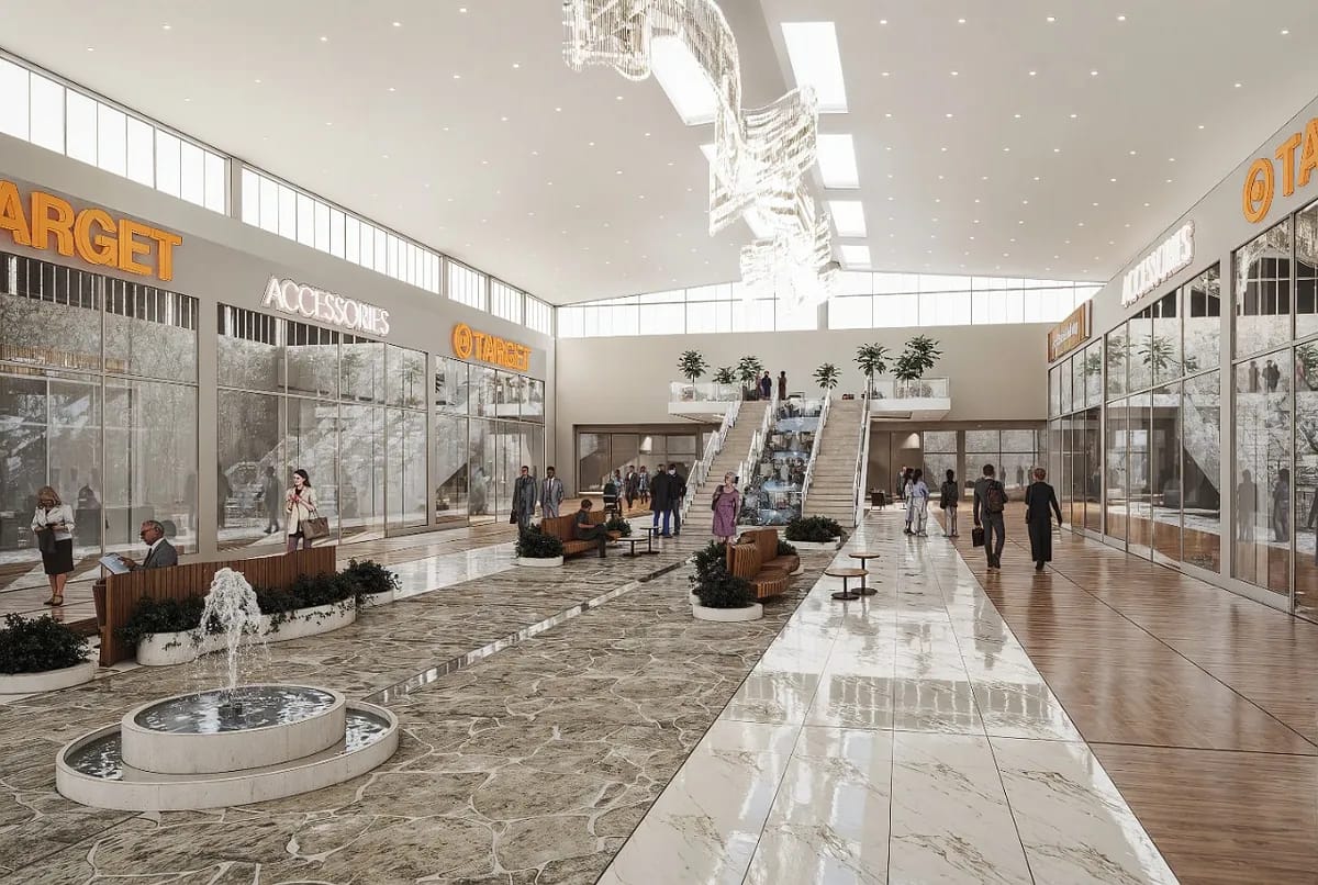 Commercial interior with water fountain, seating areas, escalators, and large storefront windows.