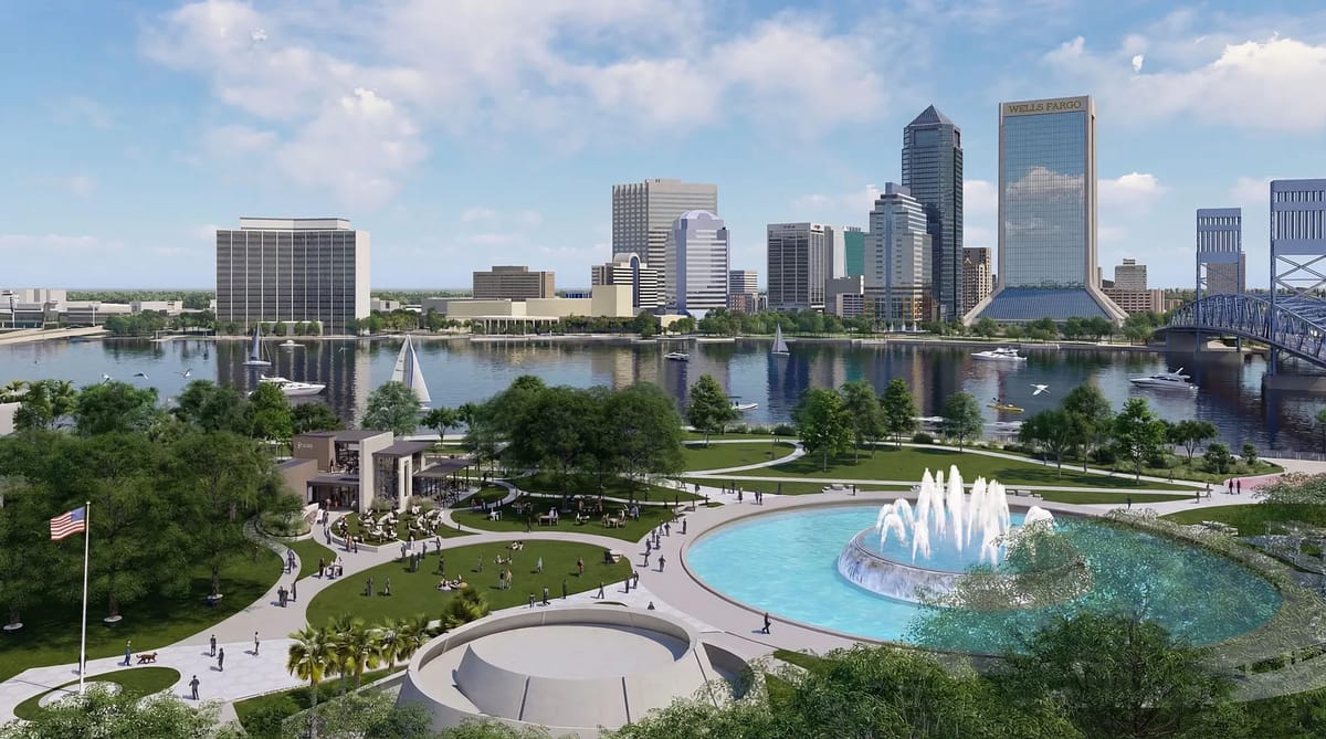 Outdoor park with circular fountain, trees, grass, and city skyline in the background.