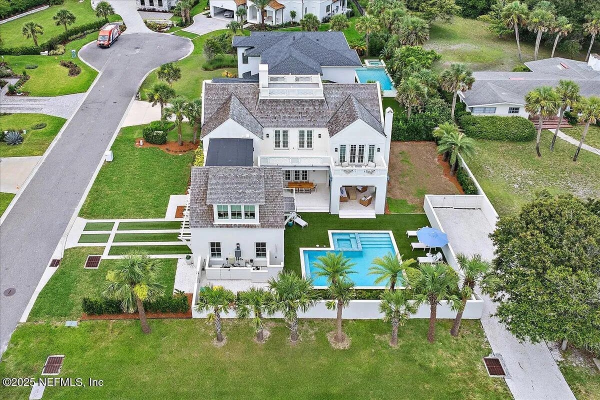 Exterior view of a two-story house with landscape, swimming pool, and balconies.