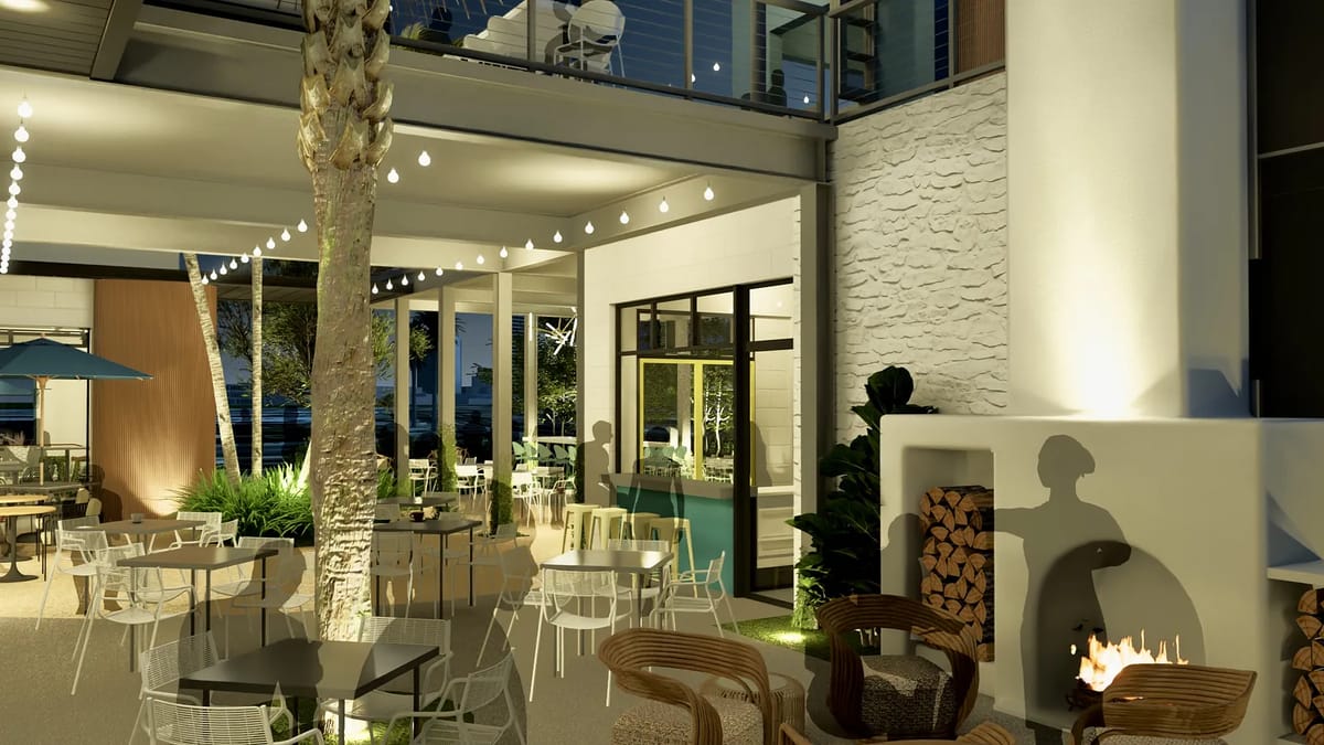 Patio with outdoor seating, stone fireplace, green bar area, and string lights.