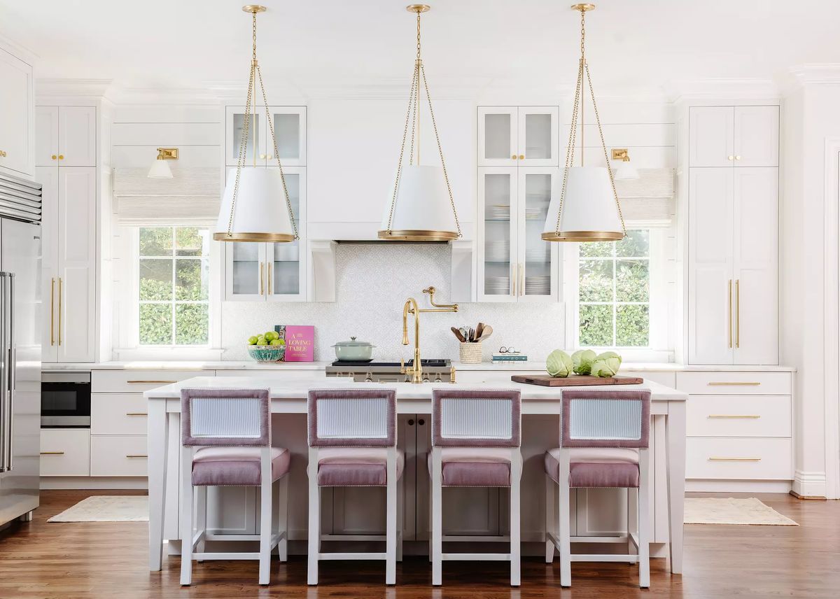 Kitchen with island, bar stools, stainless steel refrigerator, custom cabinetry, and large windows for natural light