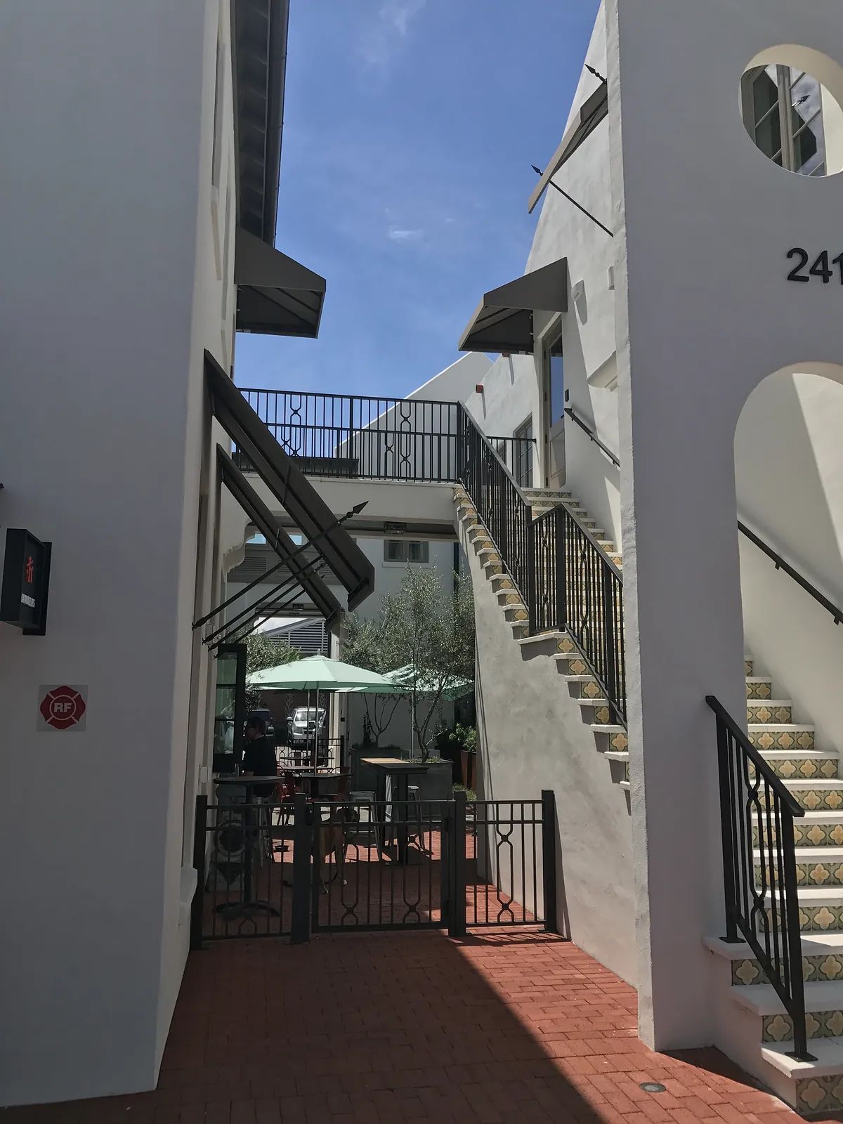 Exterior area with staircase, tiles, railings, gated entrance, and recreational seating