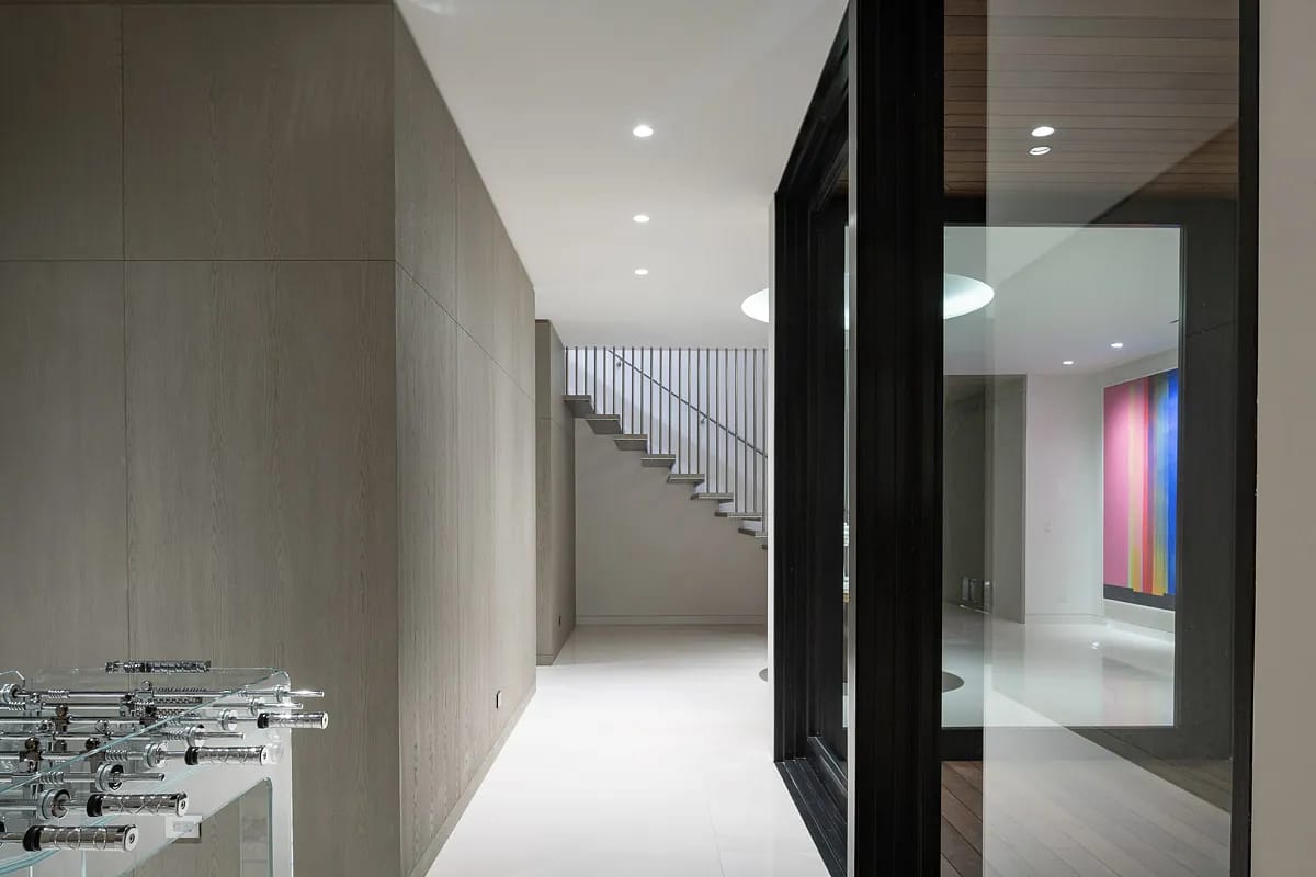 Foyer with staircase, glass door, textured walls, side table, and colorful artwork