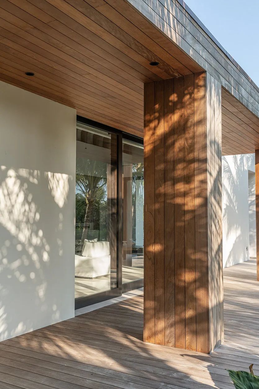Exterior front view with wooden column, glass window, and wooden deck.