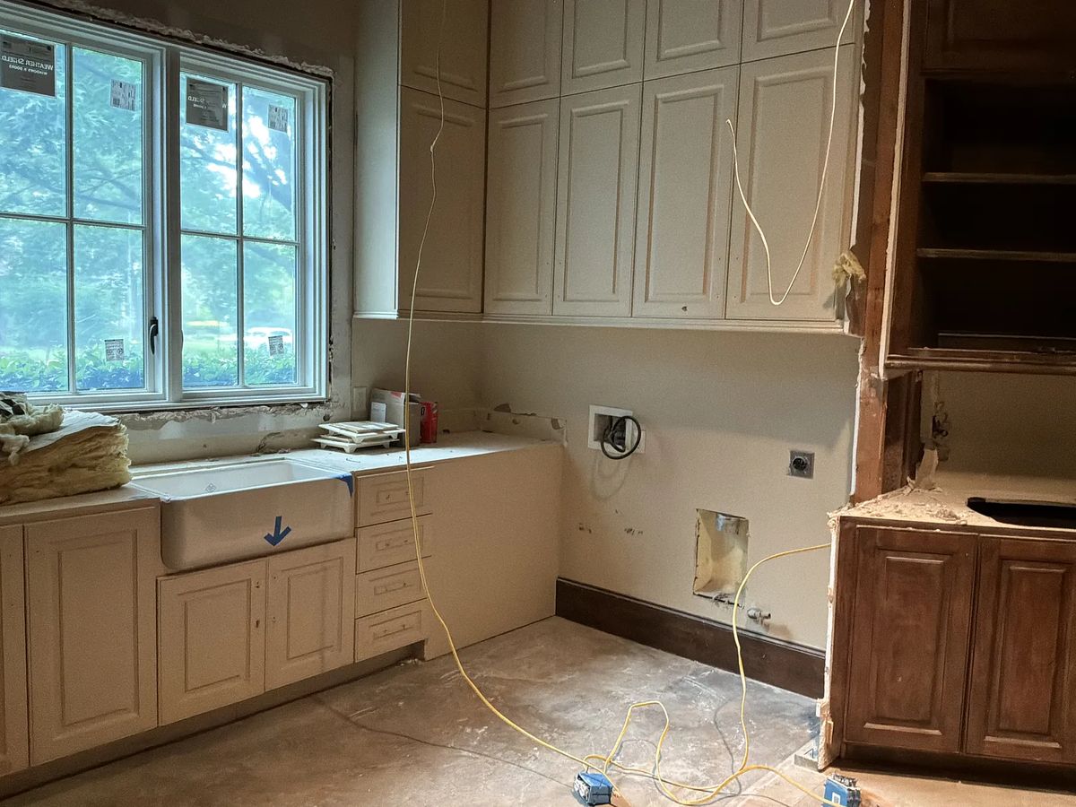Kitchen area with farmhouse sink, light cabinetry, and unfinished counter.