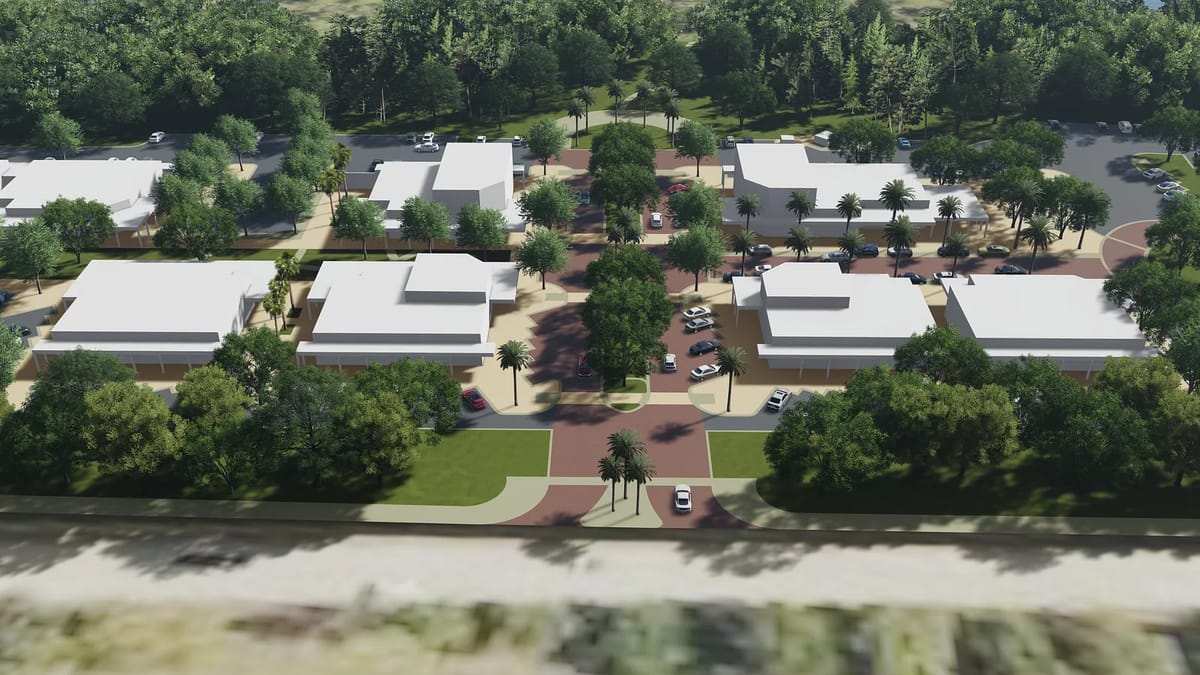 Aerial view of residential community with buildings, roads, green spaces, and palm trees.