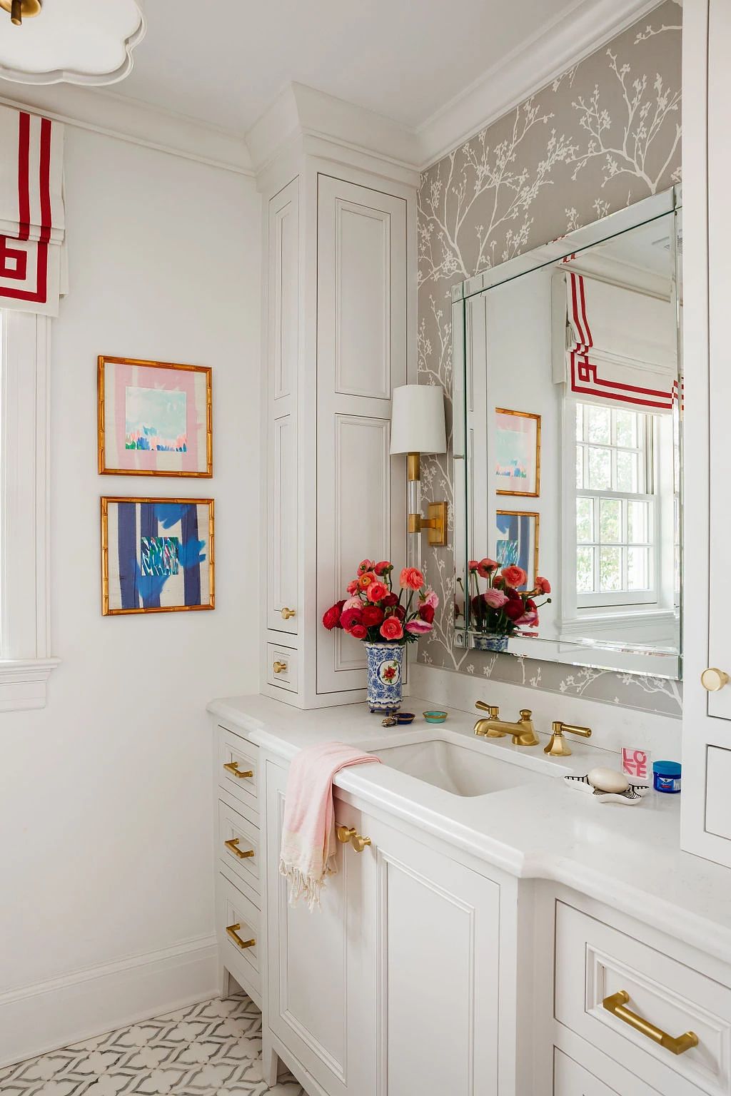 Bathroom with white cabinetry, marble countertop, large mirror, floral artwork, and striped curtains.
