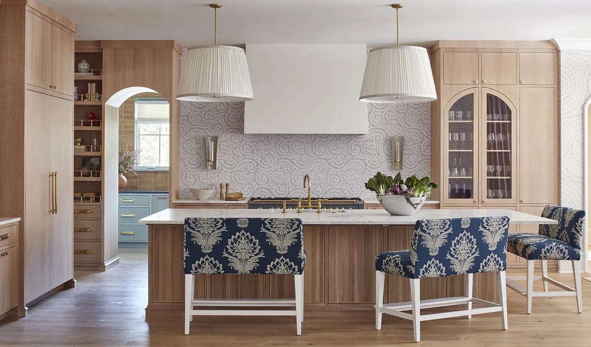Kitchen with central island, patterned bar stools, wooden cabinetry, and decorative backsplash.