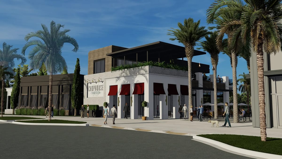 Exterior front of a two-story building with white brick, awnings, outdoor seating, and palm trees.