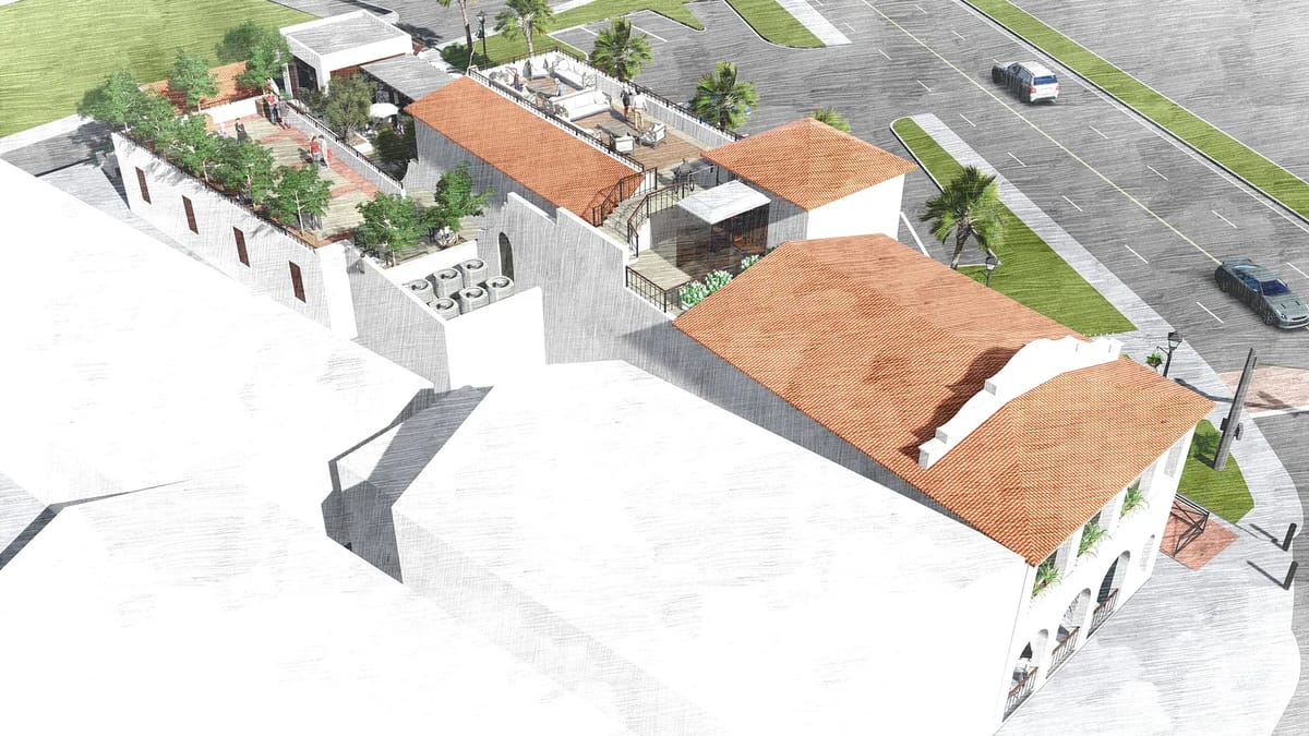 Exterior front view of building with terracotta roofs, palm trees, planters, and upper terrace with seating.