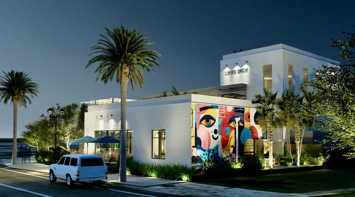 Exterior of a modern building with vibrant mural, palm trees, and white vehicle parked.