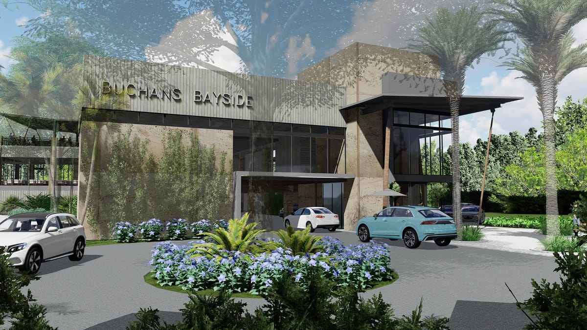 Exterior front view of a building with large glass windows, landscaped entrance, and parked cars.