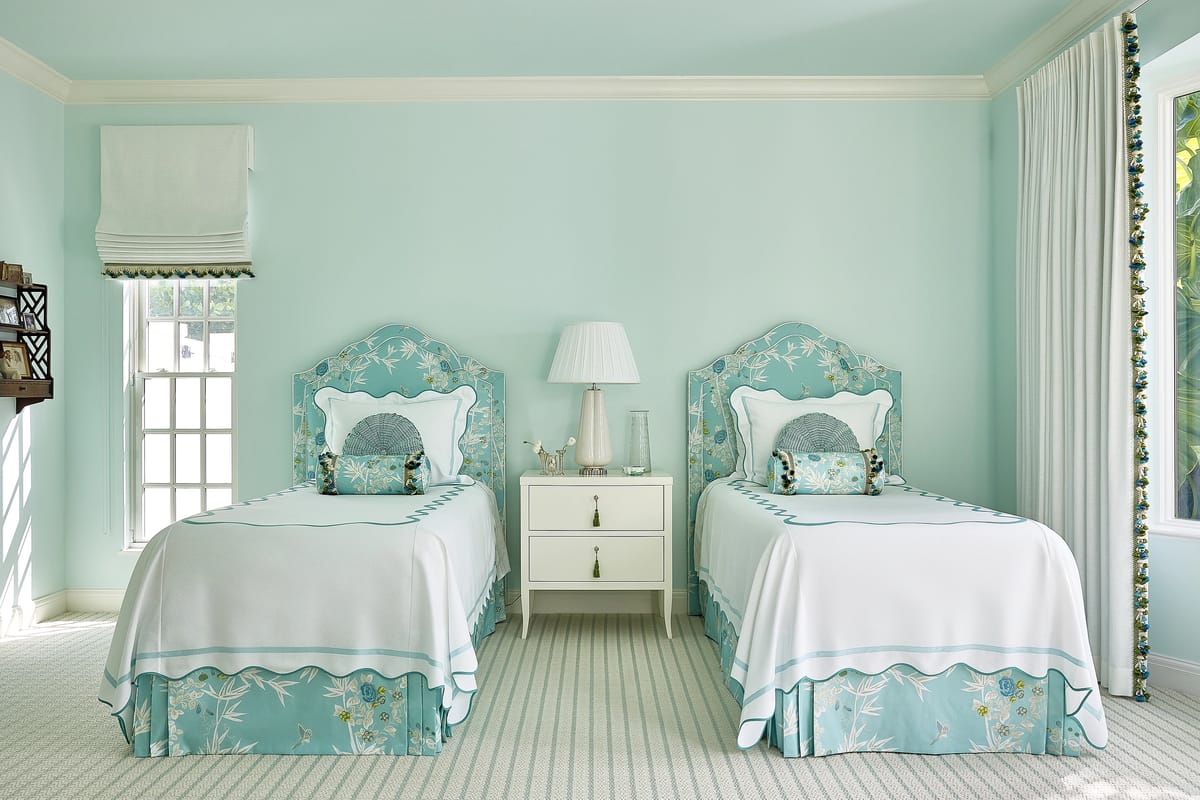 Bedroom with two twin beds, floral headboards, nightstand, and light aqua walls.